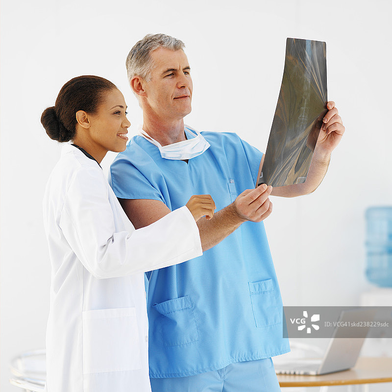 两名医务人员检查x光片的侧视图图片素材