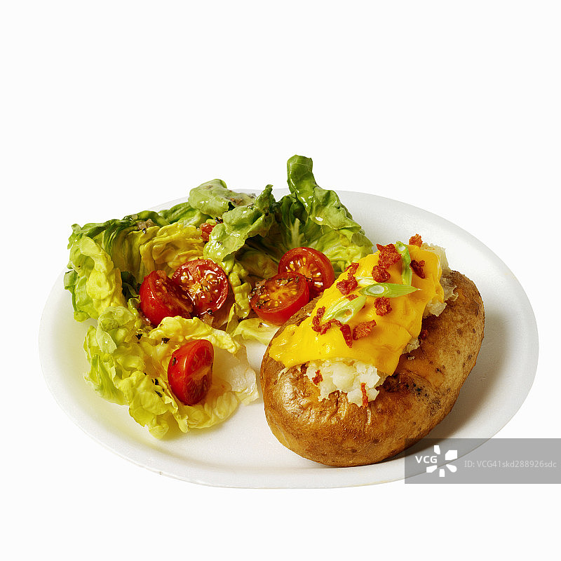 这是沙拉和烤土豆的特写，配上奶酪和韭菜图片素材
