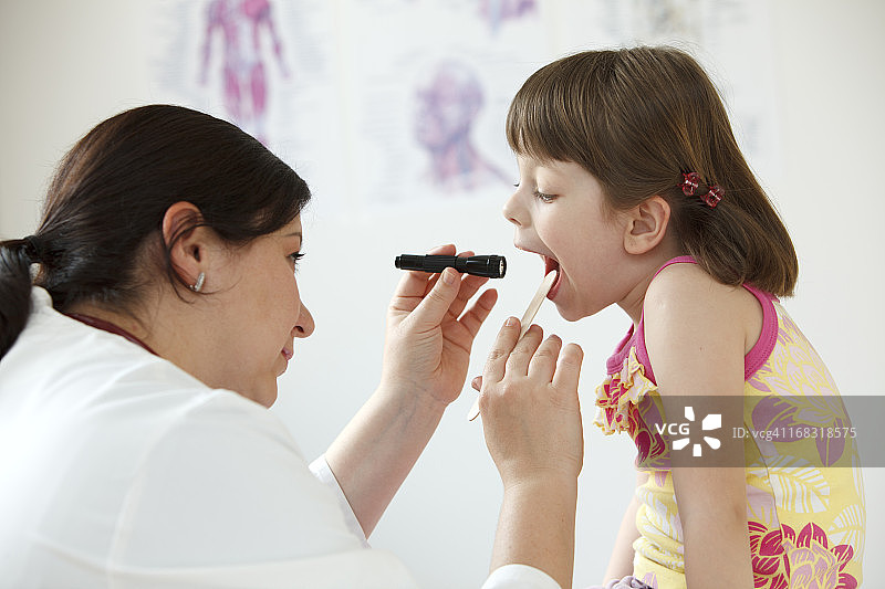 女儿科医生检查儿童的喉咙图片素材