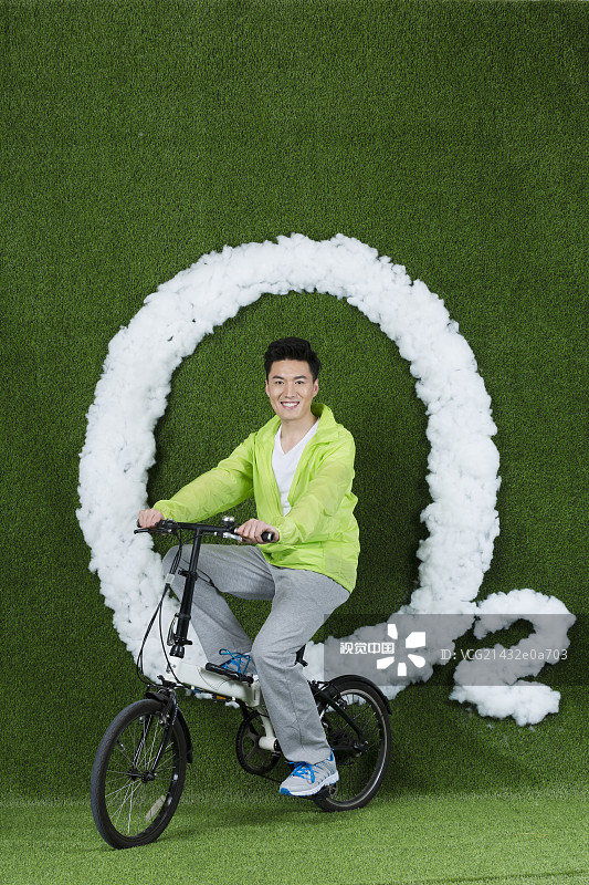 草地创意男青年骑自行车图片素材