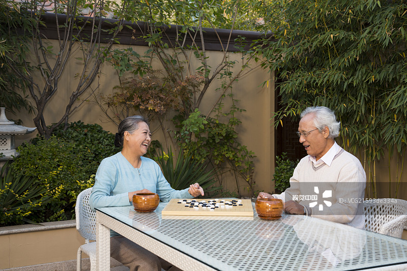 老夫妻在庭院里下棋图片素材
