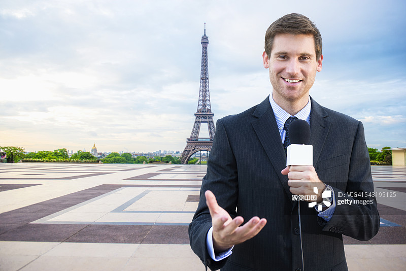 一名白人新闻记者在法国巴黎埃菲尔铁塔附近谈话图片素材
