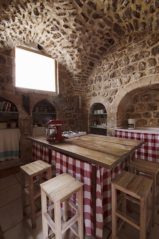 厨房柜台与格子布窗帘的基础和木制酒吧凳子在老房子石灰石墙壁和拱形天花板图片下载