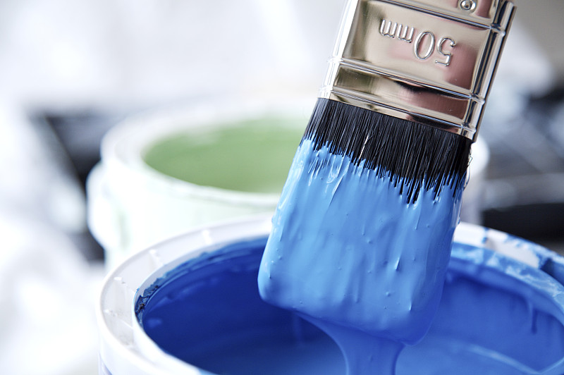 特写的蓝色油漆壶和滴水的油漆刷图片下载