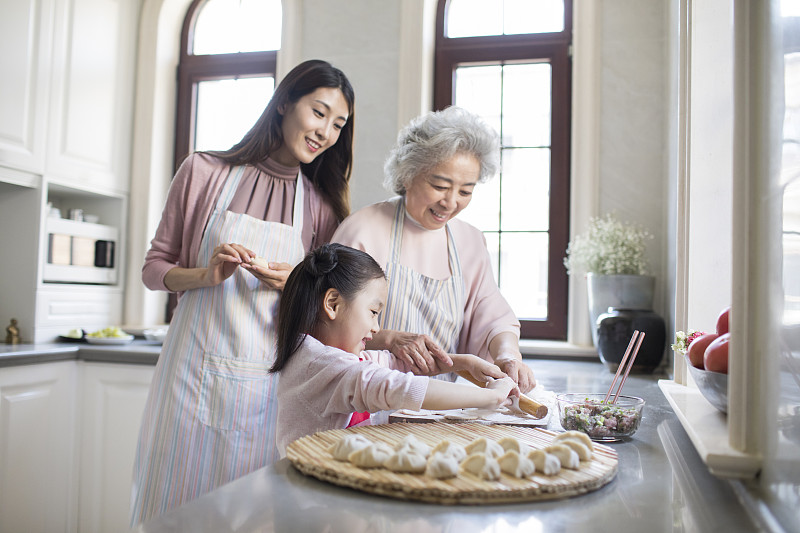 快乐的家庭在厨房包饺子图片下载