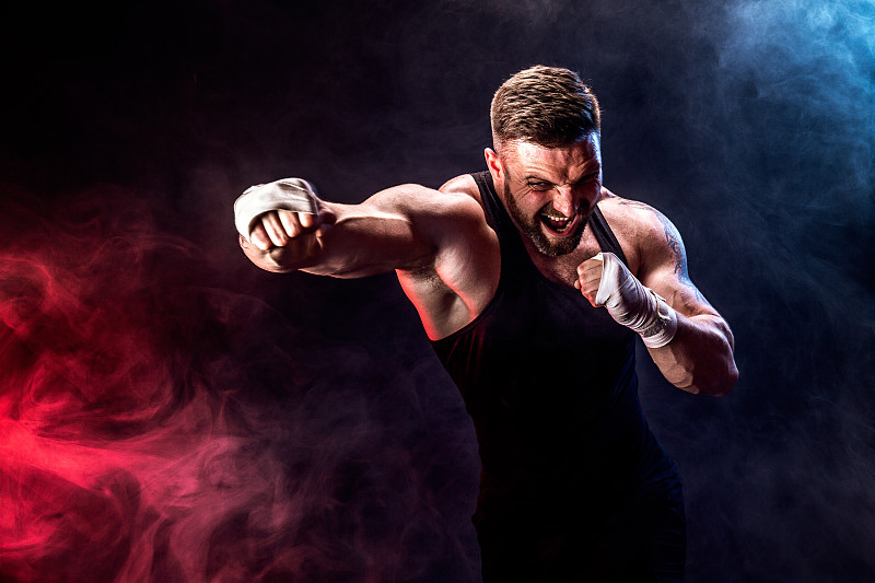 运动员泰拳拳击在黑色背景与烟雾图片下载
