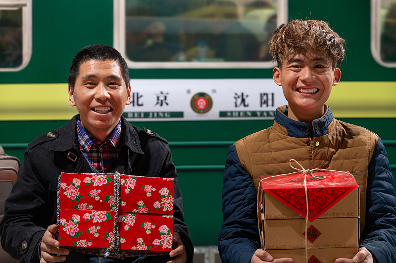 站在火车月台上拿新年礼物的旅客图片下载