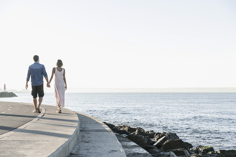 西班牙,一对中年夫妇沿着海岸散步图片下载