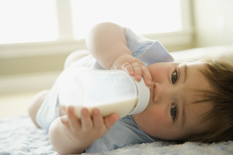 小男孩喝着奶瓶里的牛奶图片下载