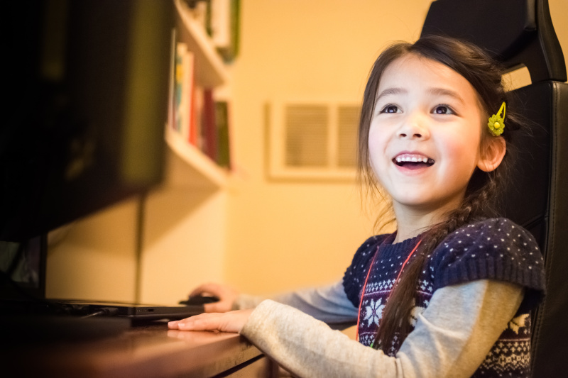 快乐的小女孩在家里玩电脑图片下载