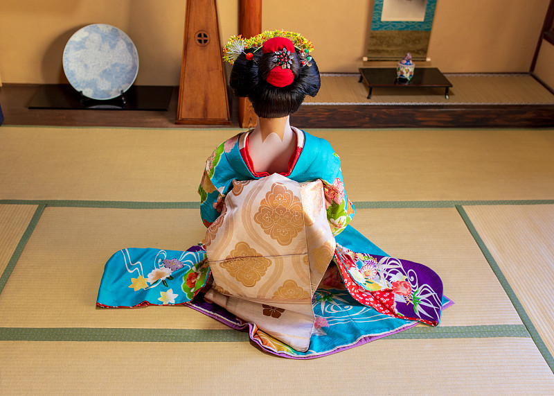 后视图舞妓学徒坐在脚跟在传统的日本榻榻米房间图片下载