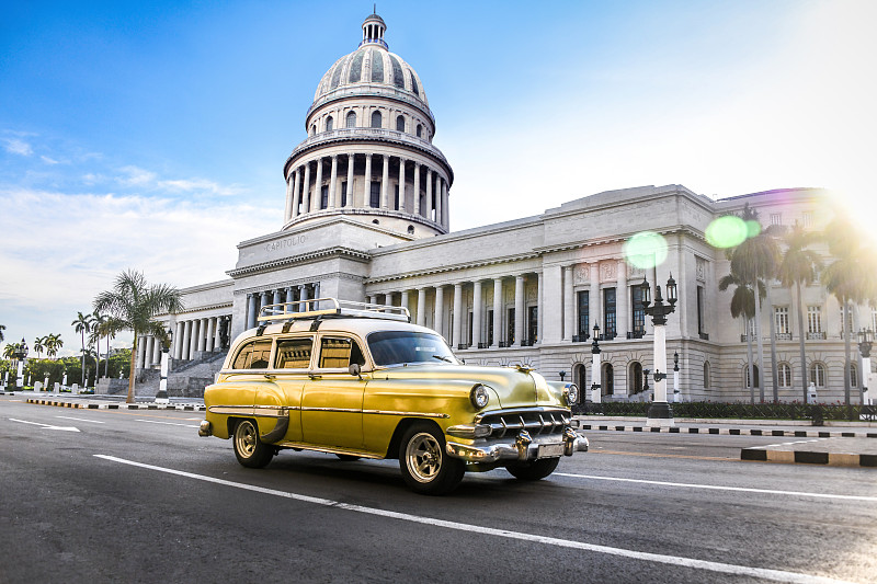 古巴哈瓦那El Capitolio大厦前的一辆黄色老爷车图片下载