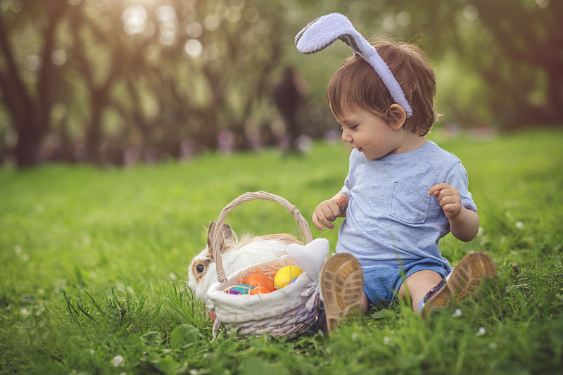 可爱的小男孩玩兔子和复活节彩蛋图片素材