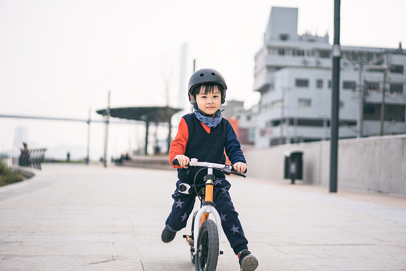 一个小男孩的肖像戴着运动头盔和骑自行车图片下载