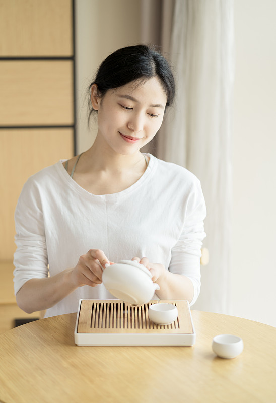 年轻的中国妇女正在喝茶图片素材