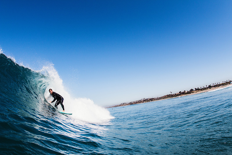 中年男性冲浪者冲浪弯曲的波浪，卡尔斯巴德，加利福尼亚州，美国图片下载