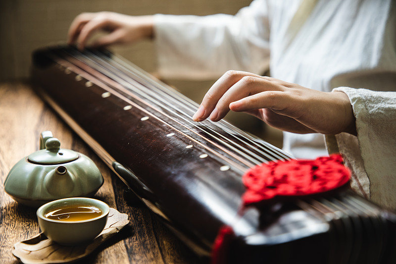 弹奏古琴(一种中国古代弦乐器)的亚洲妇女图片下载