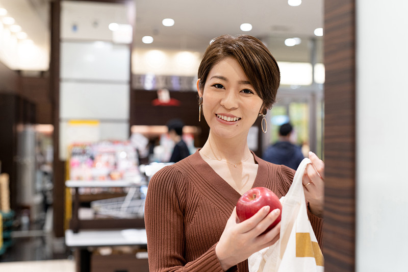 亚洲妇女在超市用可重复使用的棉花袋包装苹果图片下载