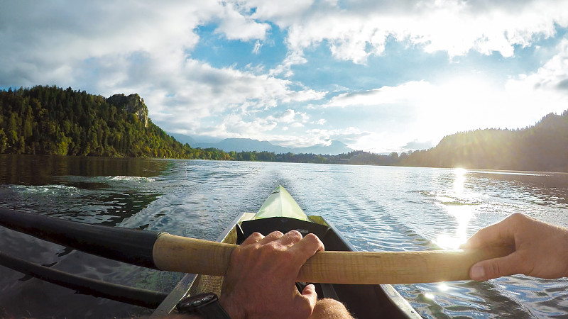 运动员在阳光明媚的湖面上划桨图片下载