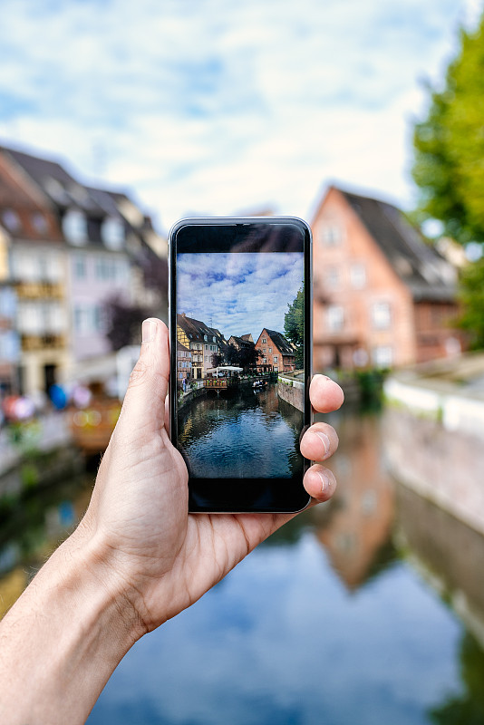 法国，科尔马，一个男人用他的智能手机拍照的手的特写图片下载