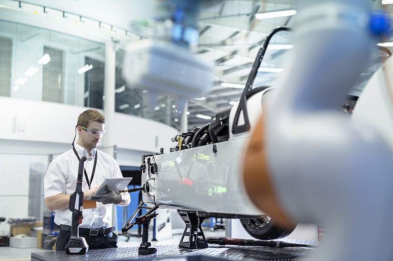 工程师和机器人在机器人研究中心检查汽车图片下载