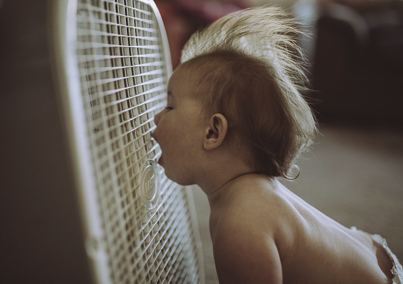赤裸上身的男婴张大嘴巴享受着家里空调吹来的微风图片素材