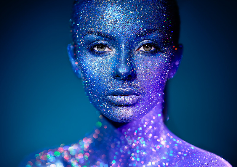 时装模特在蓝色亮片和霓虹灯在工作室摆姿势。美丽性感的女人肖像。艺术设计色彩斑斓，闪闪发光图片素材