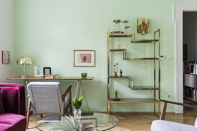 客厅的黄铜架子和精致的桌子，绿色的墙壁图片素材