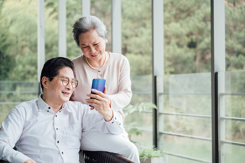 亚洲老年夫妇使用智能手机图片下载