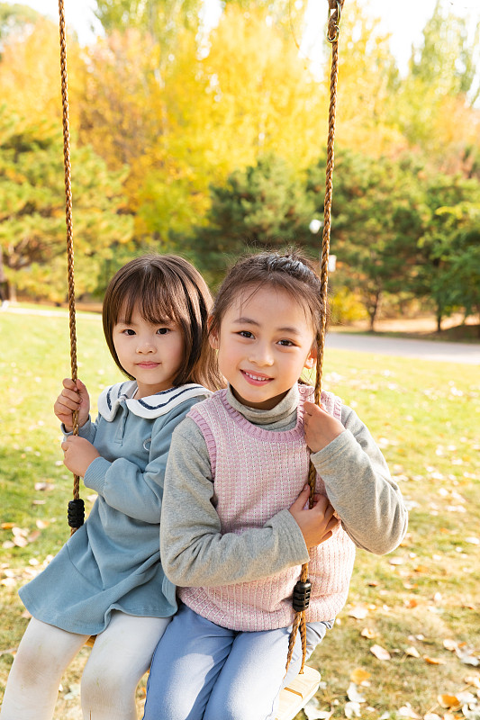 两个女孩在公园里荡秋千图片下载