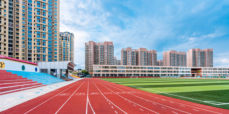 体育场的红色跑道和远处的高楼建筑图片素材