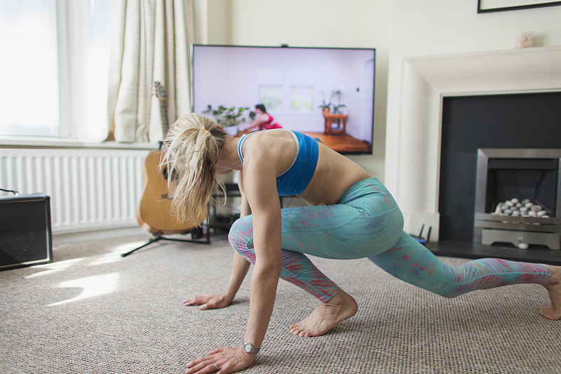 女人在客厅里练在线瑜伽图片素材