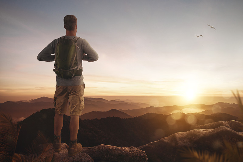 马来西亚，塔纳腊塔，日落时，男人站在山上背对着天空的后视图图片素材