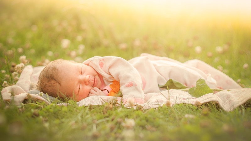 可爱的小女孩睡在草地上图片素材