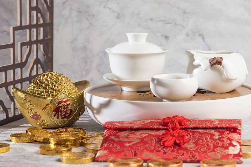 桌子上的茶具、金币、元宝和红包图片素材