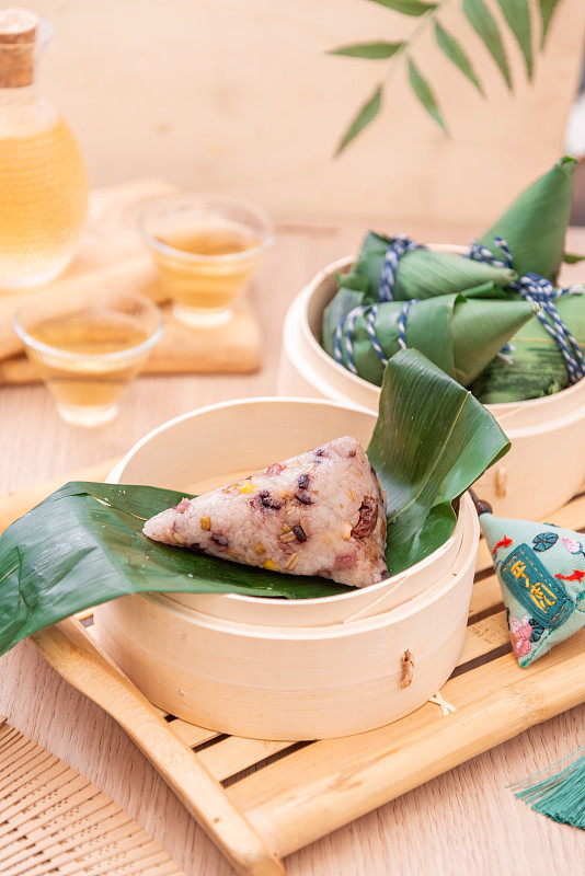 夏季端午节木桌上竹制蒸笼里的八宝粽子图片素材