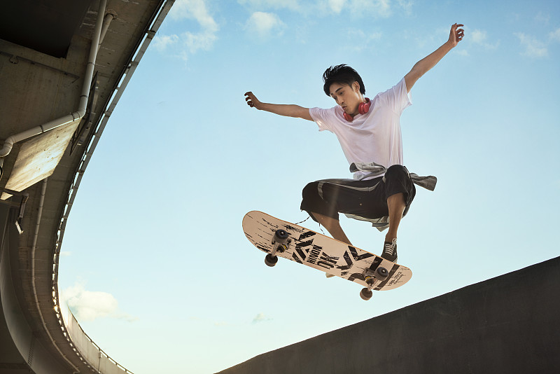 年轻男子滑滑板做极限动作图片下载