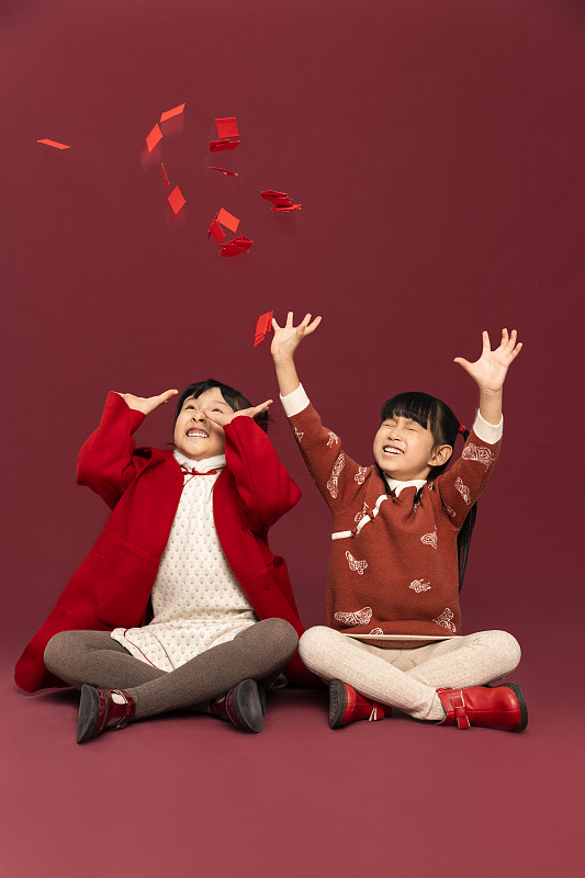 儿童庆祝春节系列：两个小女孩伸手抢春节红包图片下载
