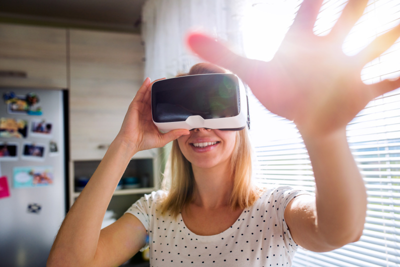 一个戴着虚拟现实眼镜的女人站在厨房里图片下载