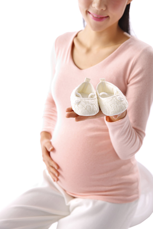 孕妇手拿婴儿鞋图片下载