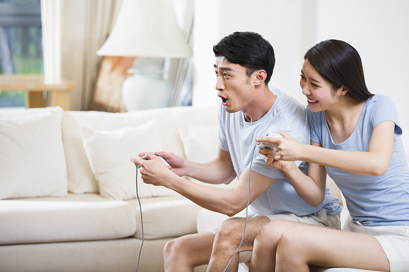 年轻夫妇在一起玩电子游戏图片下载