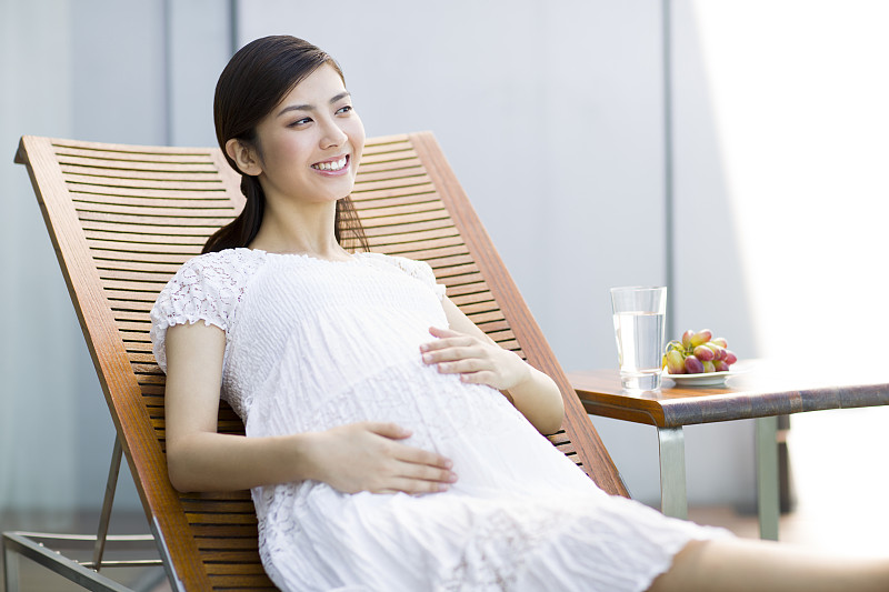 孕妇靠在躺椅上休息图片下载