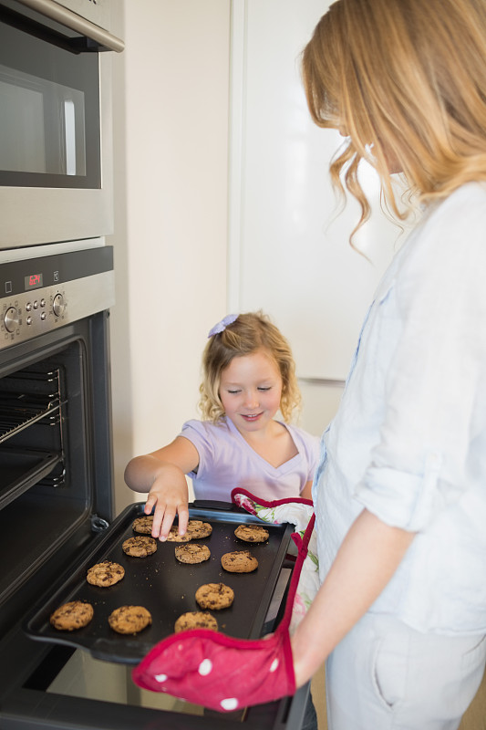 母亲和女儿在厨房里一起烤饼干图片下载