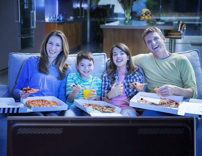 一家人在客厅看电视吃披萨图片下载