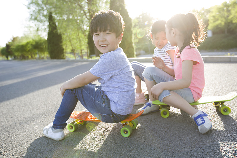快乐的儿童坐在滑板上图片下载