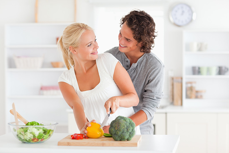 一对幸福的夫妇在厨房里切辣椒图片下载