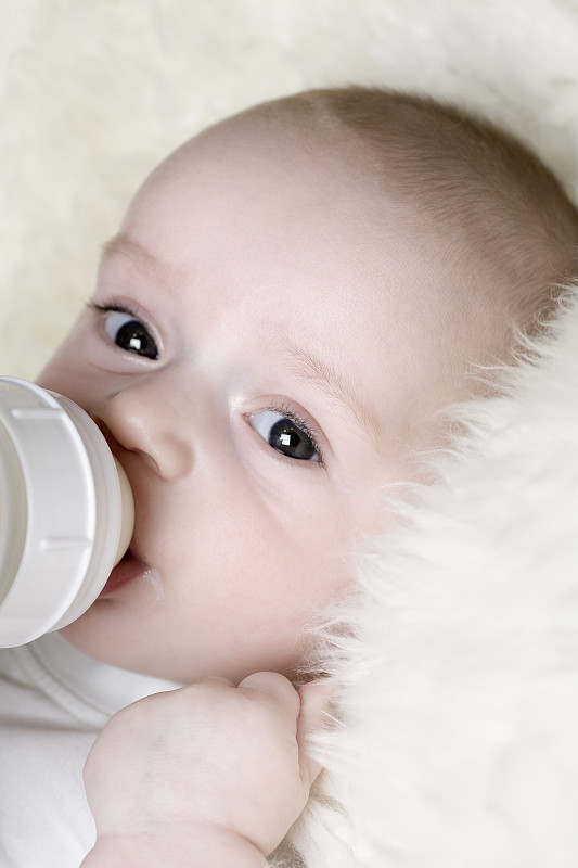 一个正在吸奶瓶的婴儿图片下载