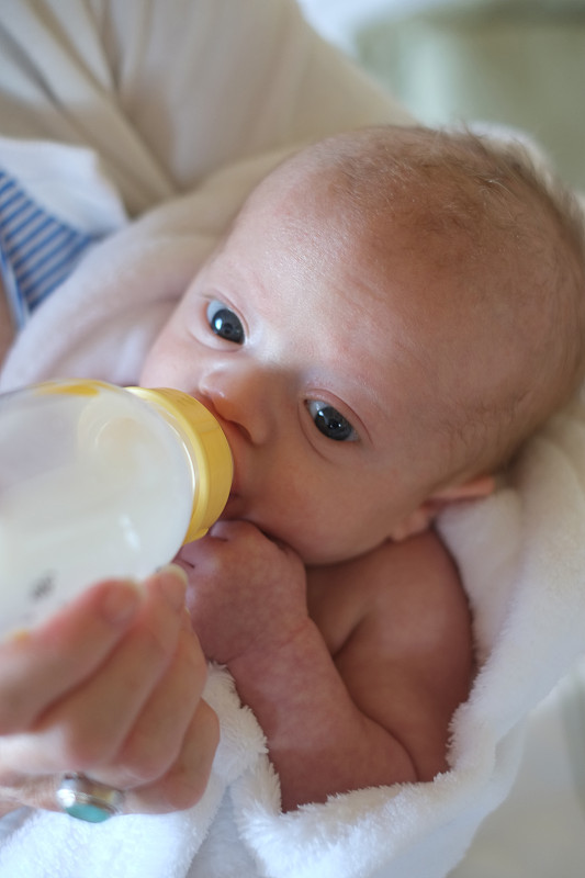 母亲用奶瓶喂新生婴儿图片素材
