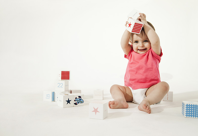 微笑的婴儿玩着积木图片下载
