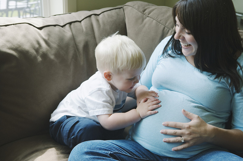 男孩(2-4人)微笑着摸着孕妇的肚子图片下载